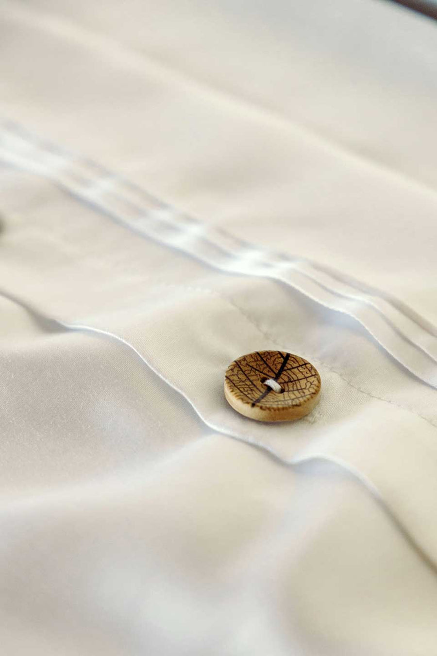 Olive button detail on THON's eco-friendly TENCEL™ Lyocell Sateen packaging.