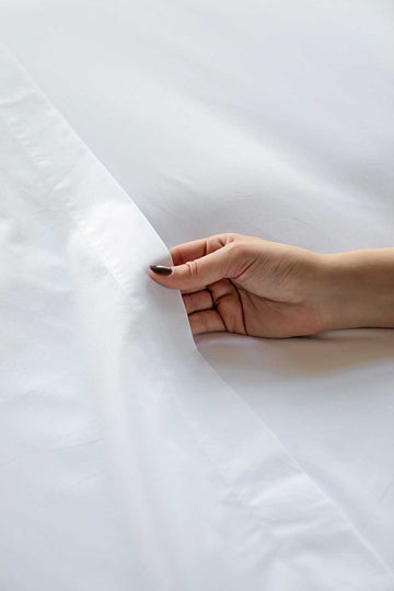 Woman touching a white flat sheet from THON.
