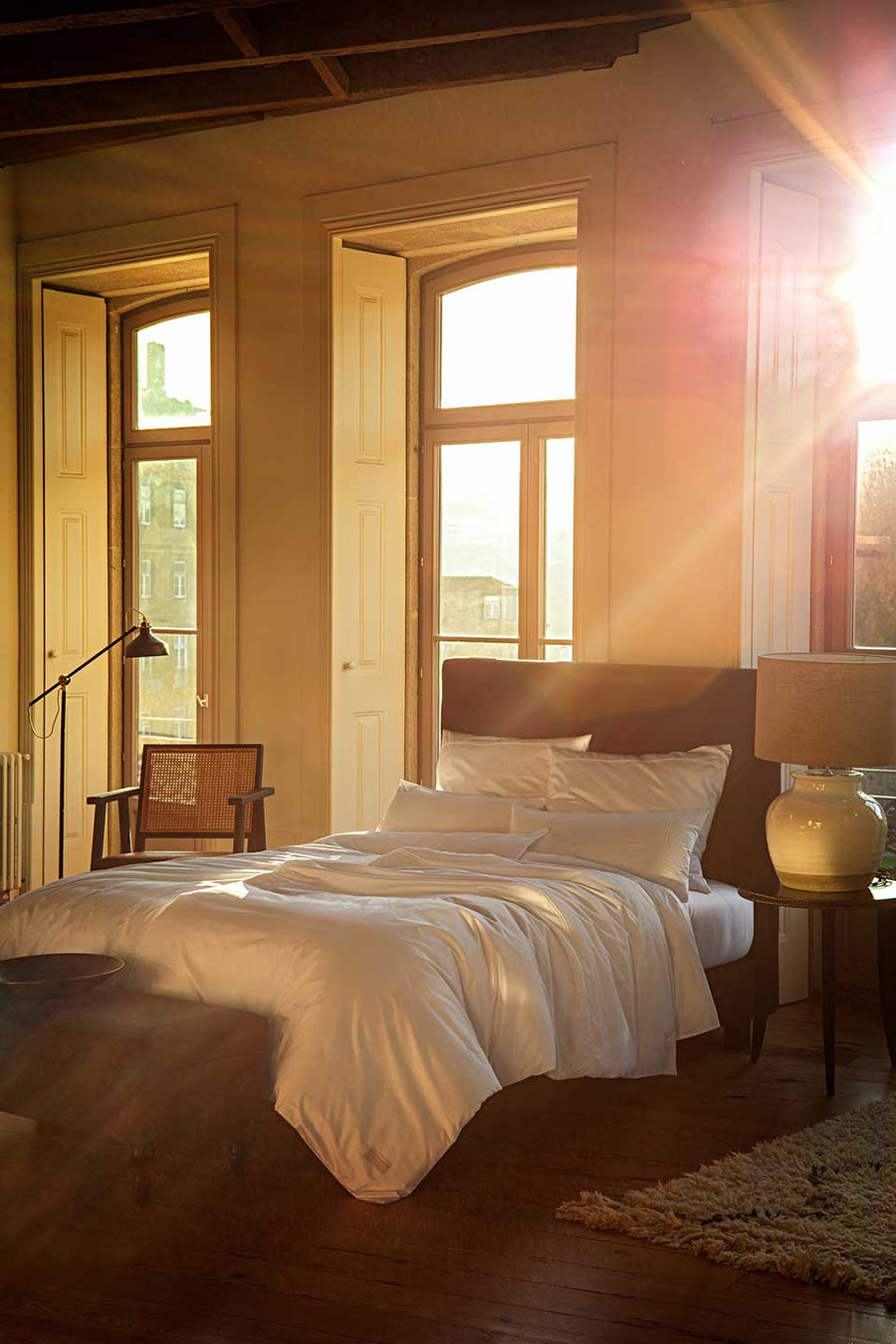 Bedroom with large windows where the sunset can be seen and with bedding in Egyptian™ Cotton Sateen.