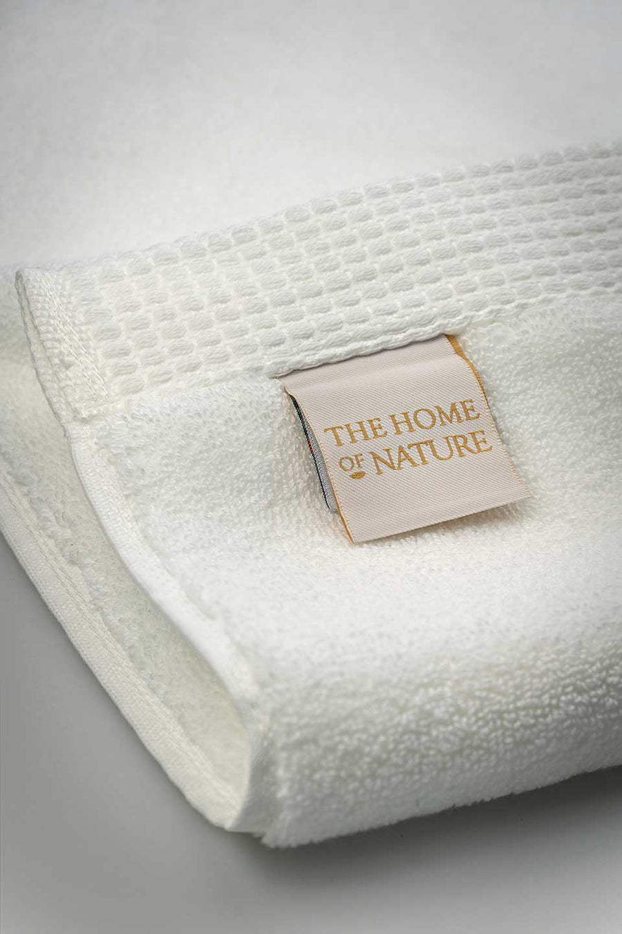 The Home of Nature label on a white Egyptian Cotton™ Bath Mat.